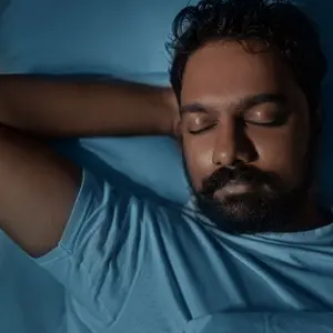 Indian man sleeping in bed at home at night