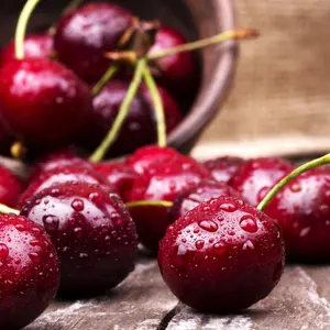 Cherries on wooden table with water drops macro background