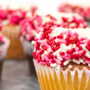 Tray Full of Vanilla and Chocolate Cupcakes Decorated with White Frosting and Red, White and Pink Sprinkles