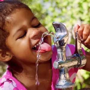 Child Drinking From Outdoor Water Fountain