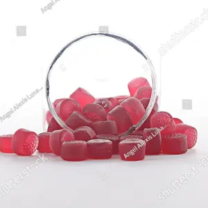 Red melatonin gummies in front with a white background