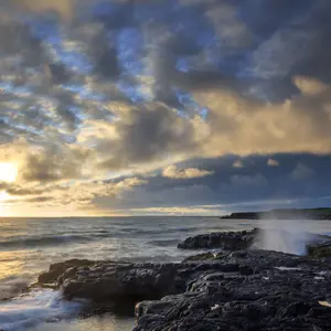A rocky ocean shore of during sunset