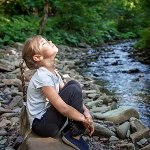 Girl sitting on side of a stream Girl sitting on side of a stream