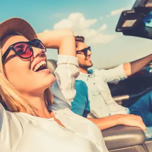 Couple driving in convertible car