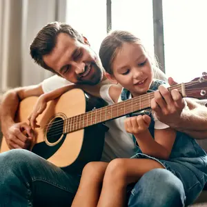 Man playing guitar with little girl