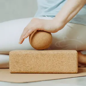 Side view of person doing palmar fascia release with a large cork ball on a cork block
