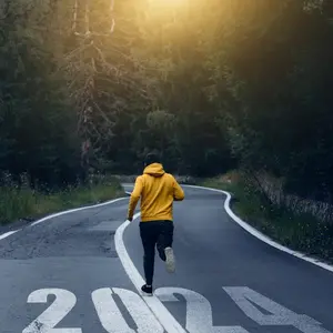 Man running on the mountain road towards new goals in 2024