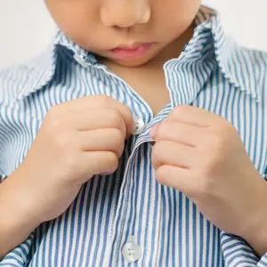 Close up of a little kindergarten boy's hands learning to get dressed