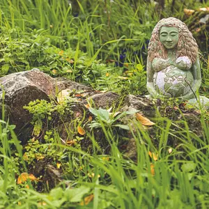 Statue of Gaia or Gea pregnant among the vegetation of a garden