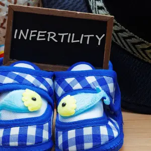 Infertility concept with blue baby shoes