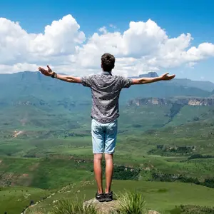 Freedom, man with outstretched arms looking over valley