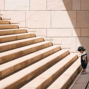 Child standing at the bottom of a great staircase