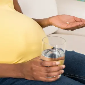 Close-up Of Pregnant Woman Holding Medicine With Glass Of Water At Home Close-up Of Pregnant Woman Holding Medicine With Glass Of Water At Home