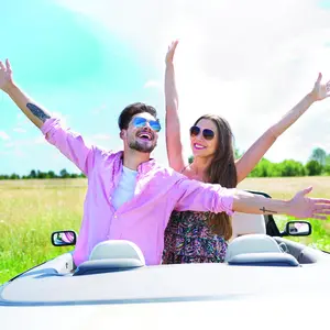 A man and a woman standing side by side, arms outstretched