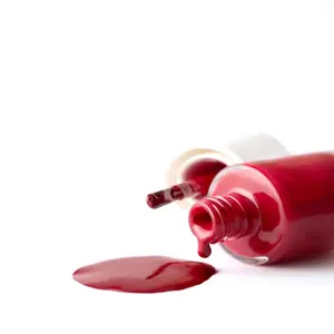Red color polish nail pouring from bottle to white background