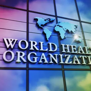 World Health Organization glass building. Mirrored sky and city on modern facade.