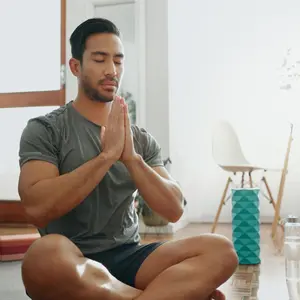 young man meditating inside his home