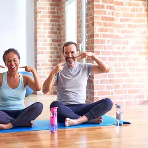 Woman and man doing yoga and pointing to their teeth