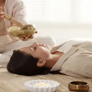 woman receives sound bath from singing bowls, which are different than Biofield Tuning methods