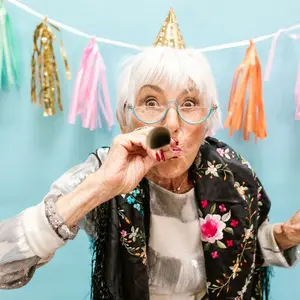 Older woman celebrating with a paper horn