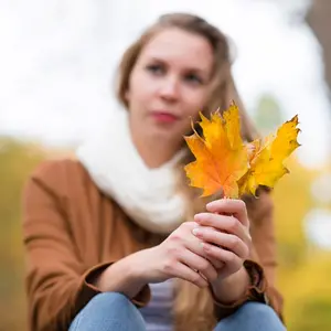 Woman holding golden maple leaves