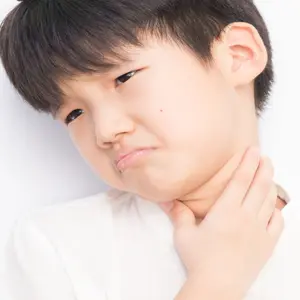 Boy holding his throat in pain, PANDAS arises from complications after strep throat