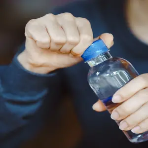 close-up hands uncapping plastic waterbottle 