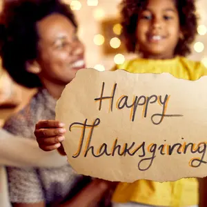 Girl holding a Happy Thanksgiving sign