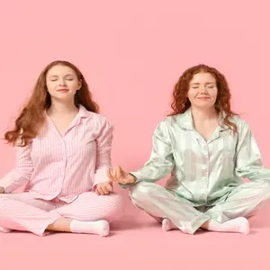 two red-head twin women meditate together side by side