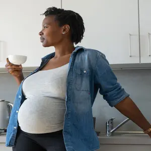Pregnant Black woman drinking a cup of tea
