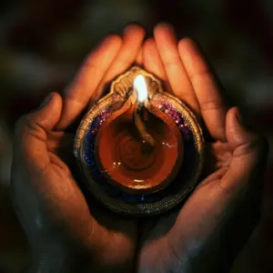Cupped hands holding a candle for ritual