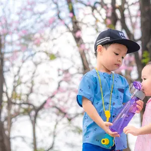 Little boy shares his water with a young girl