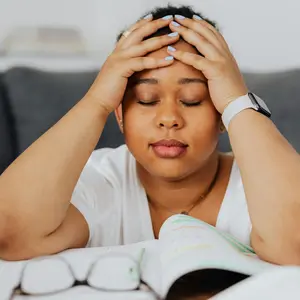 Woman holding her head, experiencing brain fog/fatigue after mental effort
